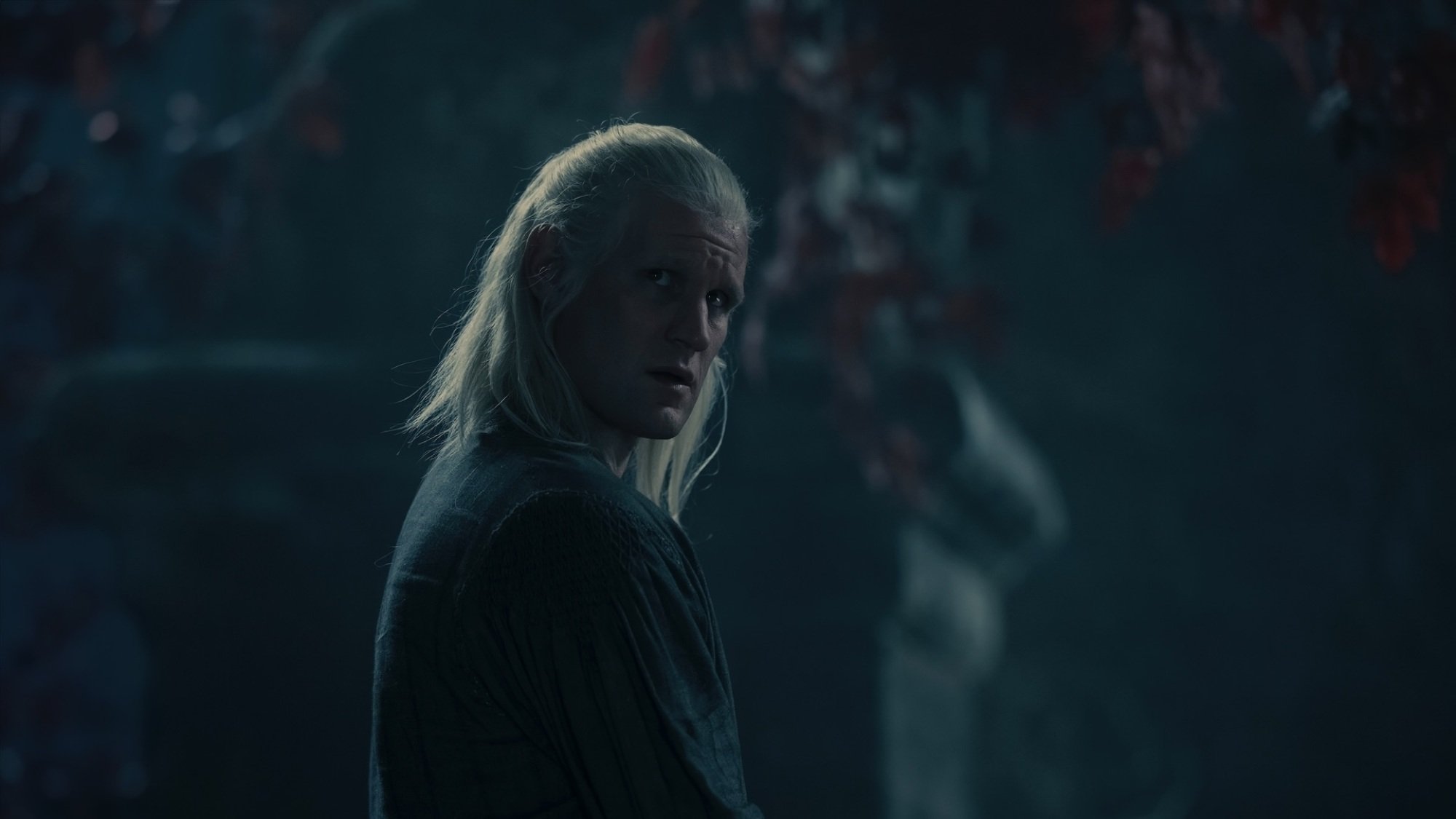 Daemon Targaryen stands under a weirwood tree at night.