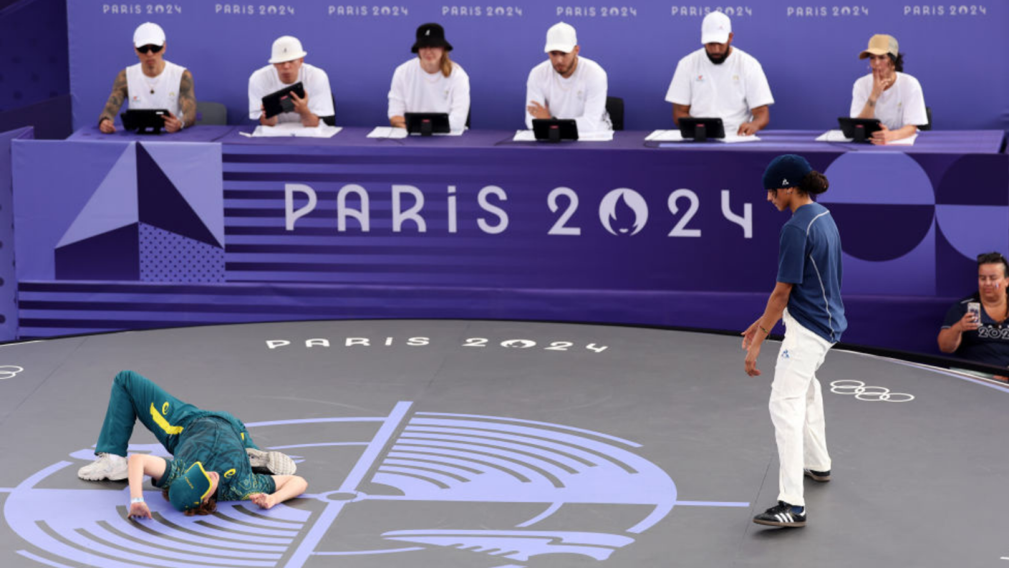 B-Girl Raygun of Team Australia competes as Syssy of Team France looks on during the B-Girls Round Robin - Group B on day fourteen of the Olympic Games Paris 2024 at Place de la Concorde on August 09, 2024 in Paris, France.