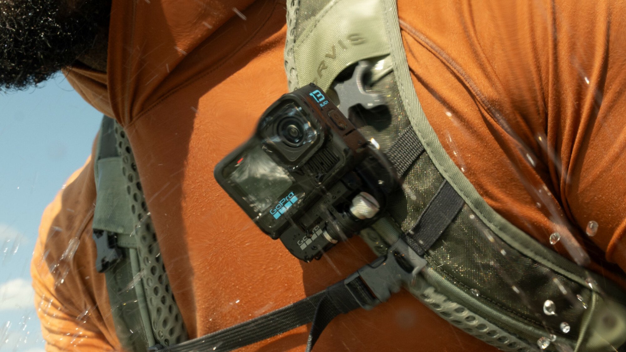 The GoPro HERO13 Black on the Magnetic Latch mount. It's attached to the backpack strap of a person moving through a wet environment.