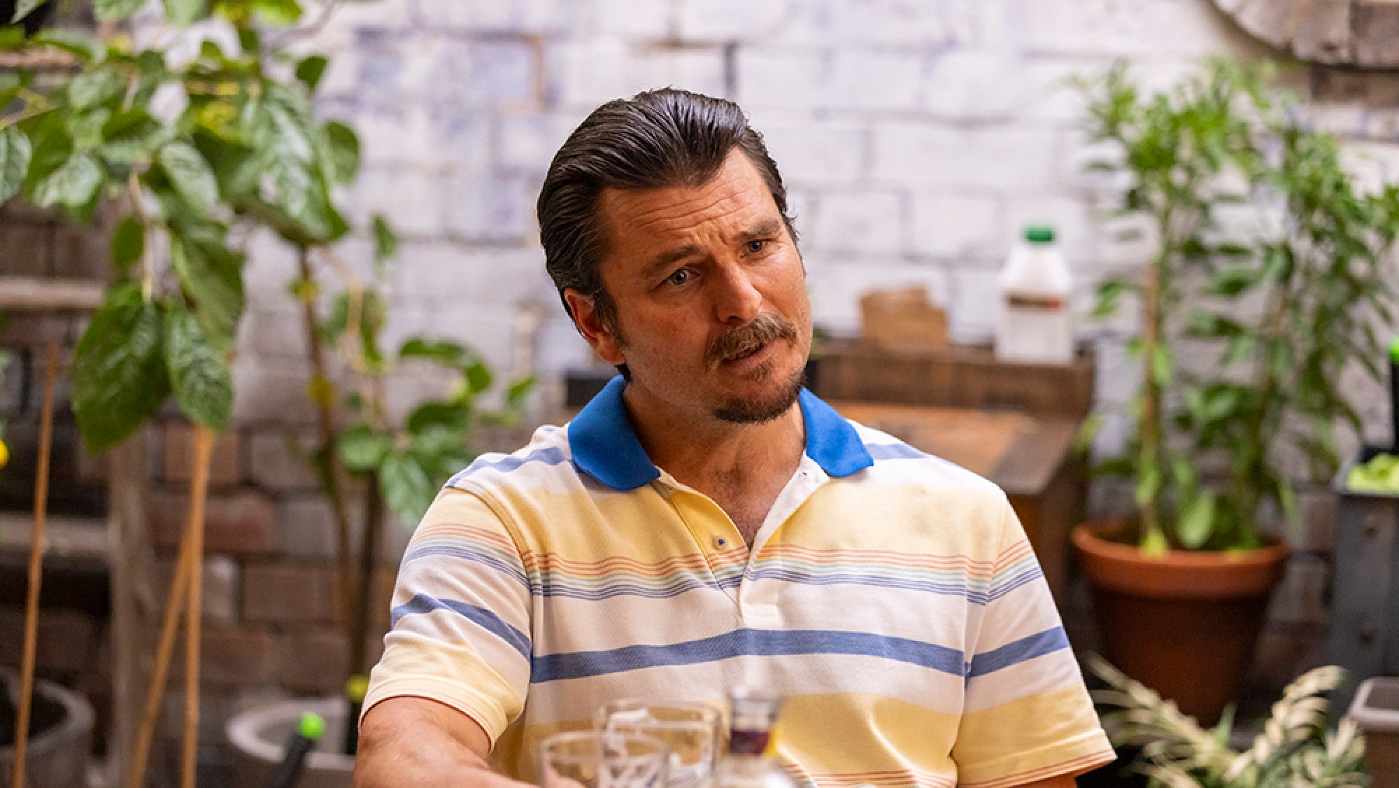 A man sits on a table outside.