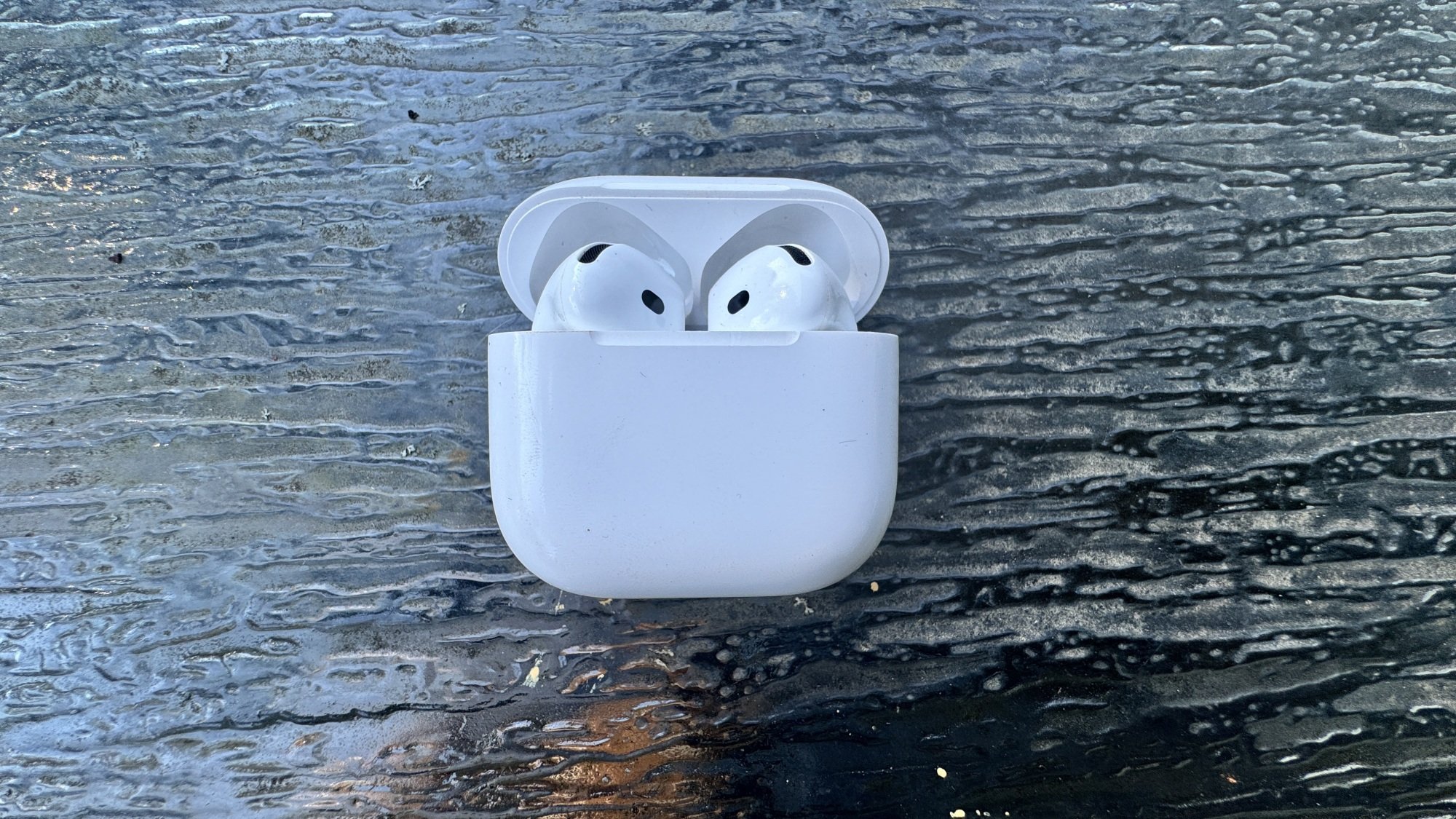 Airpods 4 on top of glass table