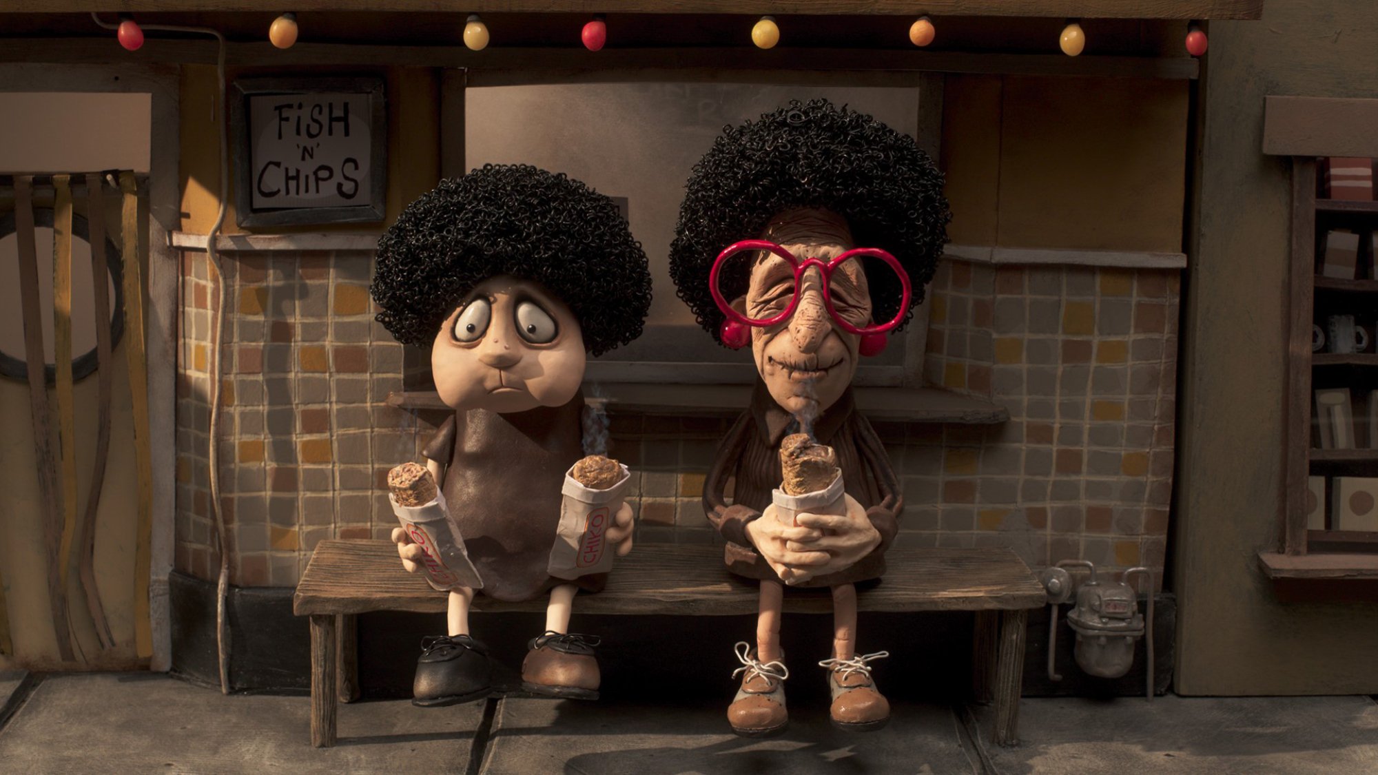 In the stop-motion film "Memoir of a Snail," two characters with the same perm sit on a bench eating Chiko rolls.